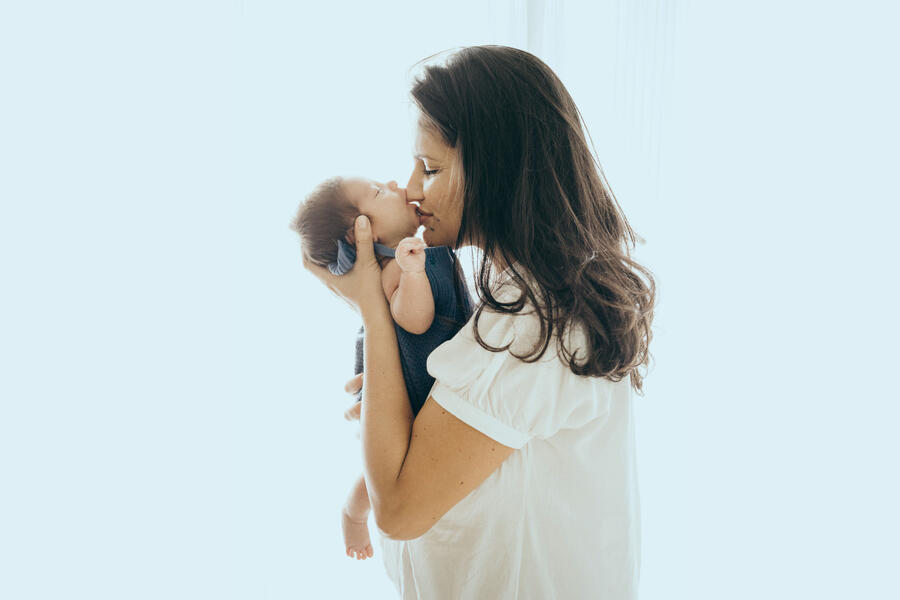 A woman holds a baby in her arms.