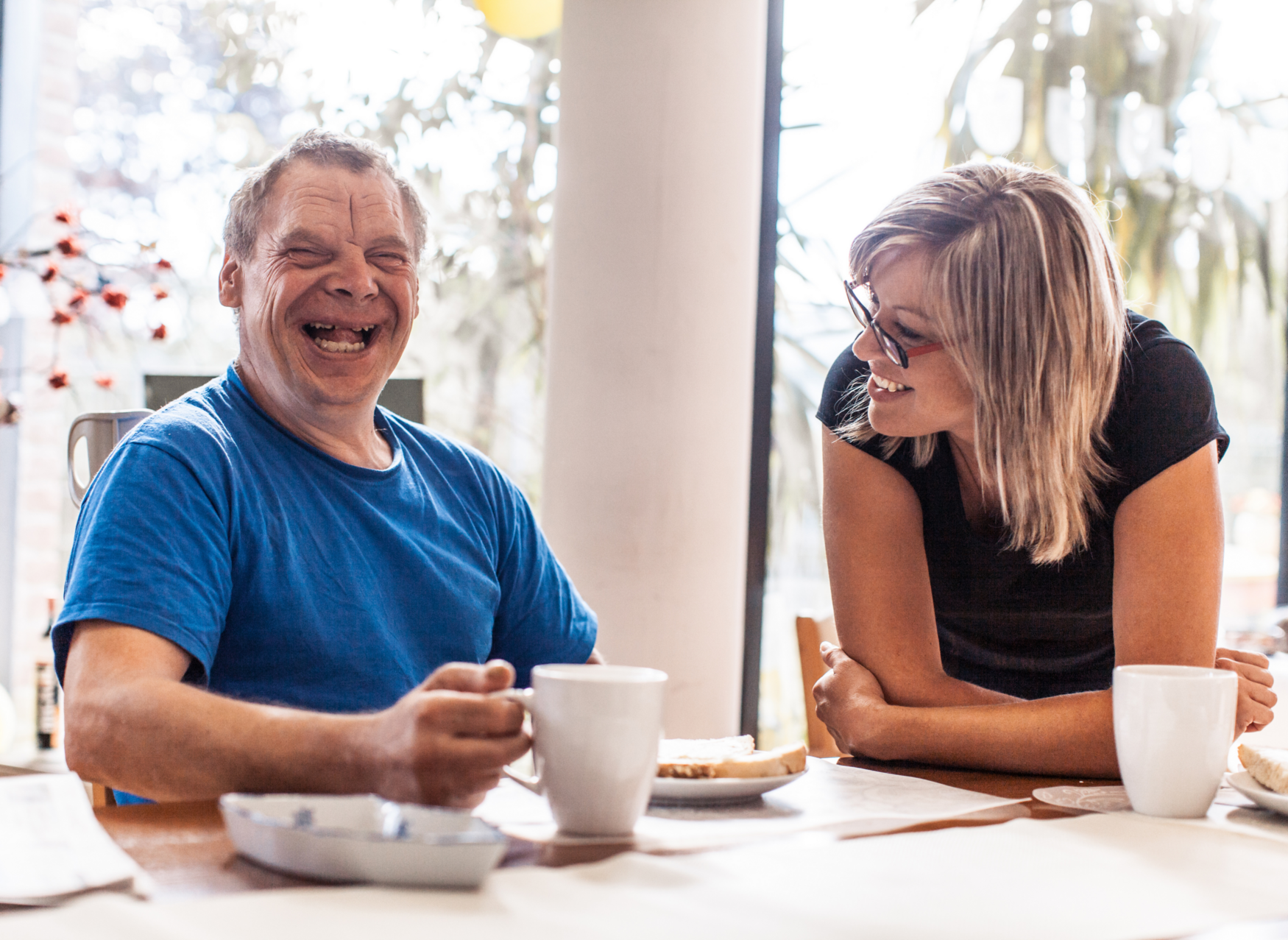 A older man and a middle-aged woman laugh together